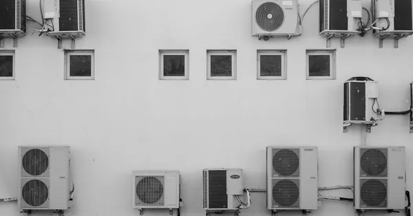 Black and white image of air conditioners mounted on a building facade in Córdoba, Argentina. wall mounted air conditioners on building facade