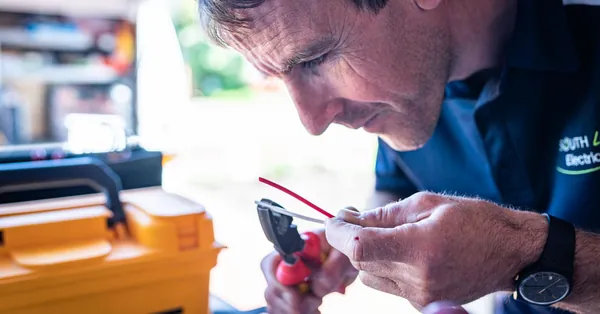 Focused technician working on wiring with tools in a workshop setting. electronics technician working with wiring tools