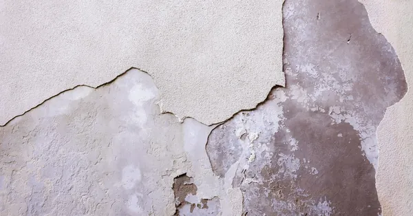 Close-up of a weathered and cracked wall with texture and detail. detailed textured cracked wall surface