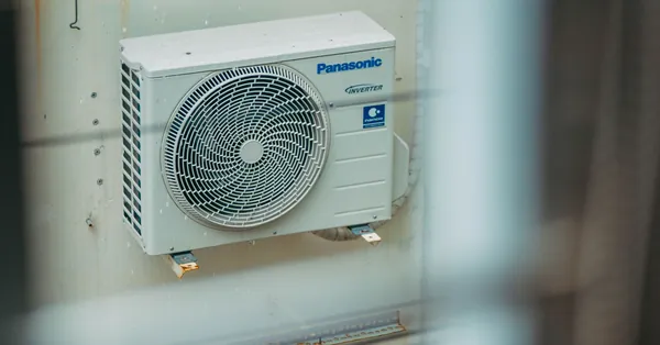 Air conditioner unit mounted outdoors on a building wall, showcasing modern HVAC technology. view of the air conditioning unit outside the building