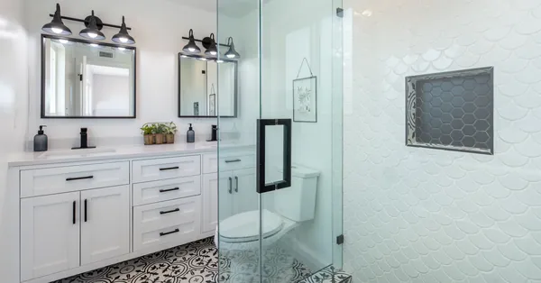Elegant white bathroom with glass shower and stylish patterned floor. photo of a bathroom