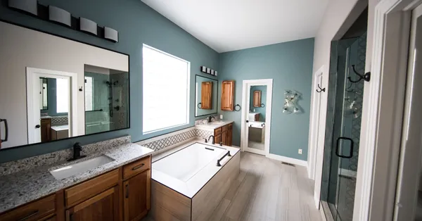 Spacious modern bathroom featuring a freestanding bathtub, wooden cabinets, and granite countertops. photo of a bathroom